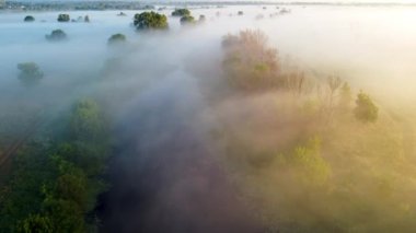 Şeffaf bulutların altında vadiyi kesen nehrin olduğu muhteşem manzaranın havadan görüntüsü.