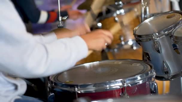 Close-up of a person in a white shirt learning to play drums. UHD, 4K — Stock Video