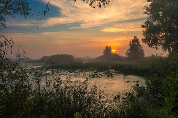 Landschap, zonsopgang, zonnestralen in de mist — Stockfoto