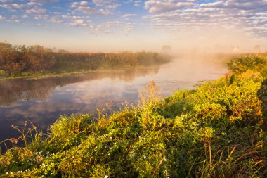 nehir ve suya yansıyan bulutlar sisli sabahı