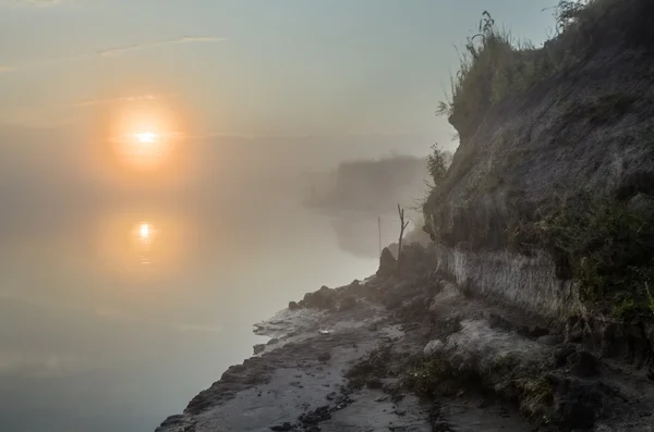 Mistige ochtend op de rivier en de wolken weerspiegeld in water — Stockfoto
