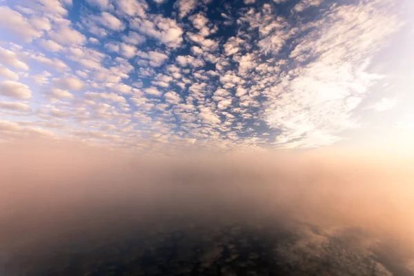 Nebliger Morgen auf dem Fluss und Wolken, die sich im Wasser spiegeln — Stockfoto