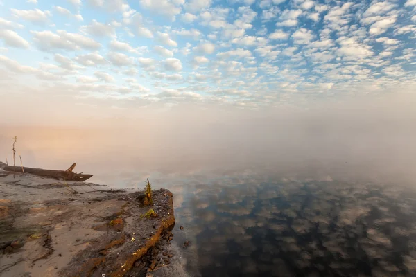 Mistige ochtend op de rivier en de wolken weerspiegeld in water — Stockfoto