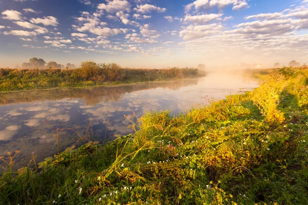 Nebliger Morgen auf dem Fluss und Wolken, die sich im Wasser spiegeln — Stockfoto