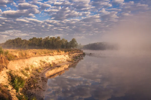 Mgliste rano na rzece i chmury odbite w wodzie — Zdjęcie stockowe