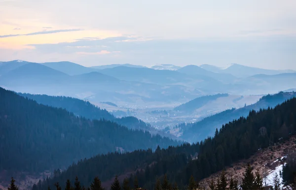 Dev dağlarla peyzaj sabah bulutlu gökyüzü altında. 