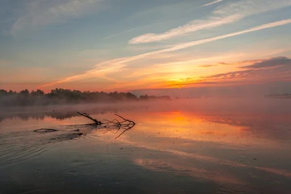 Reflexão dos primeiros raios de luz solar do amanhecer no lago — Fotografia de Stock