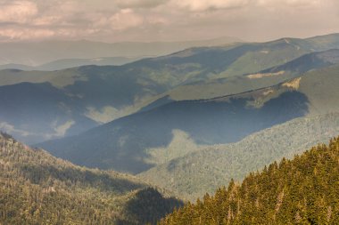 Dağlardaki yaz manzarası ve bulutlu koyu mavi gökyüzü.