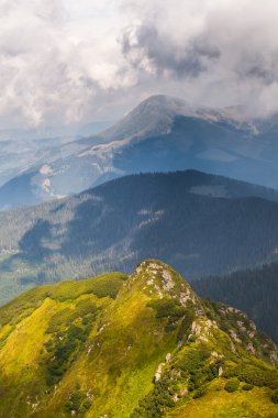 Dağlardaki yaz manzarası ve bulutlu koyu mavi gökyüzü.