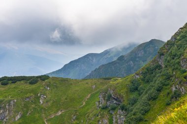 Dağlardaki yaz manzarası ve bulutlu koyu mavi gökyüzü.