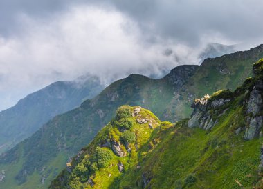 Dağlardaki yaz manzarası ve bulutlu koyu mavi gökyüzü.