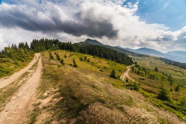 Dağlardaki yaz manzarası ve bulutlu koyu mavi gökyüzü.