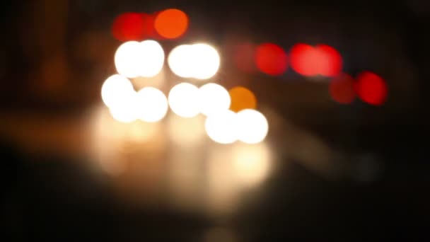Traffico cittadino fuori fuoco di notte. Fari auto e fanali posteriori fuori fuoco . — Video Stock