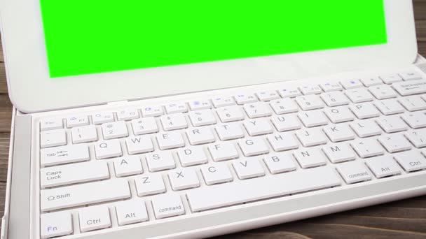 Человек печатает на ноутбуке на столе. Зеленый экран для пользовательского контента — стоковое видео