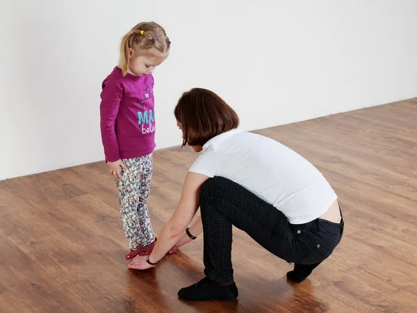Trainer showing leg position to a little girl — Stock Photo, Image