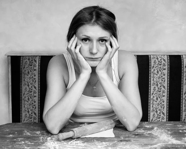 Triste mulher cansada está rolando a massa na mesa — Fotografia de Stock