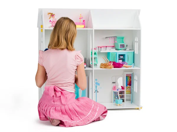 Meisje speelt met het poppenhuis vol met poppen en furn — Stockfoto