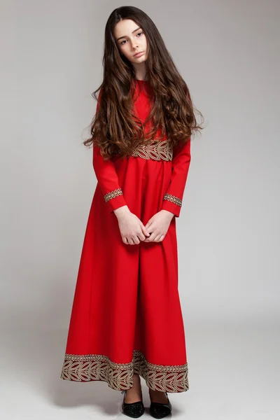 Ritratto di una triste ragazza bruna con i capelli lunghi in un vestito rosso — Foto Stock
