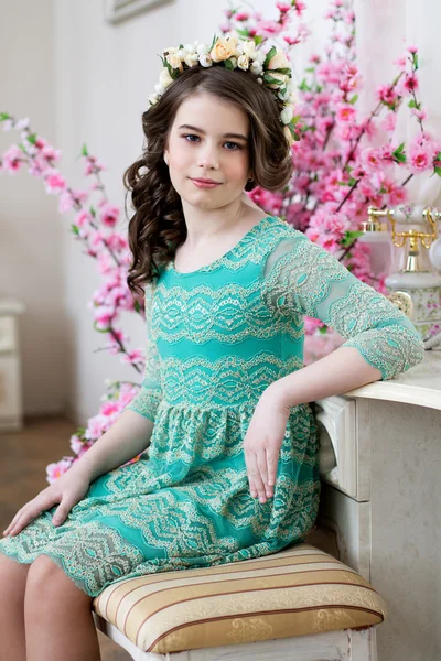 Porträtt av en söt liten flicka i en blomsterkrans — Stockfoto