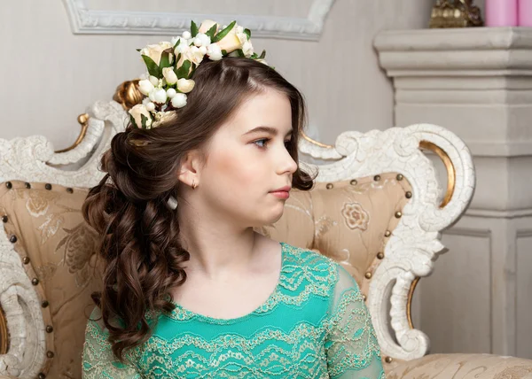 Ritratto di una bambina sorridente nella corona di fiori seduta — Foto Stock