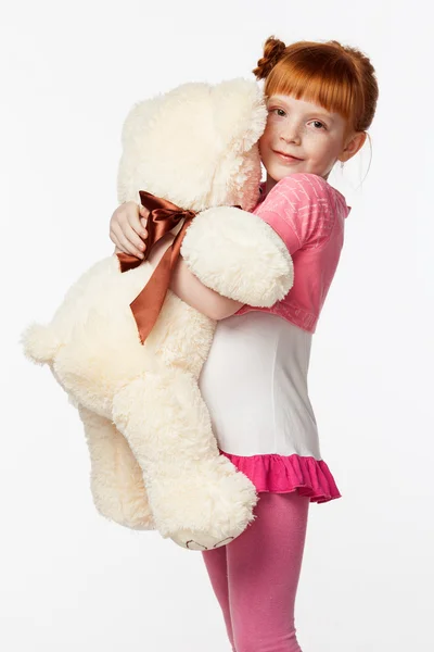 Portréja egy mosolygós vörös hajú lány rózsaszín ingben átölelve th — Stock Fotó