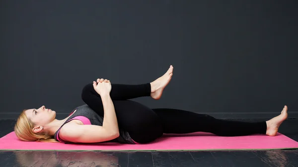 Mujer joven está haciendo ejercicios de yoga — Foto de Stock