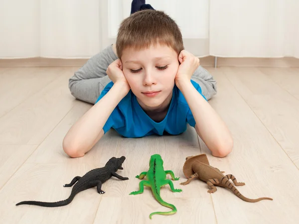 Jongen spelen met speelgoed - hagedis, dinosaurus, krokodil — Stockfoto