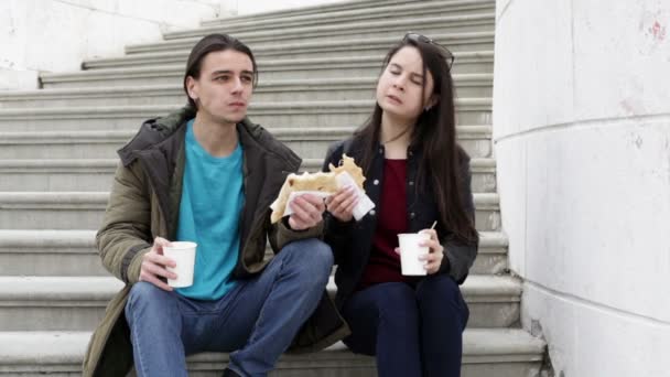 Молода пара сидить на сходах у місті — стокове відео