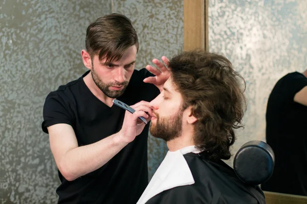 一个理发师剃须男人的胡子 — 图库照片