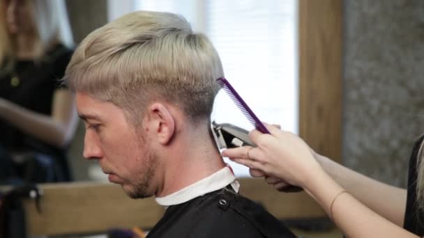 Haarstyling. Friseurin trocknet Mann den Kopf — Stockvideo