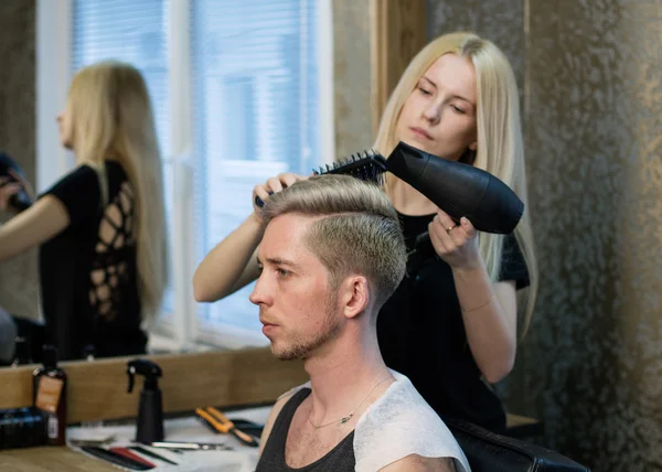 女理发师干燥男人的头发 — 图库照片