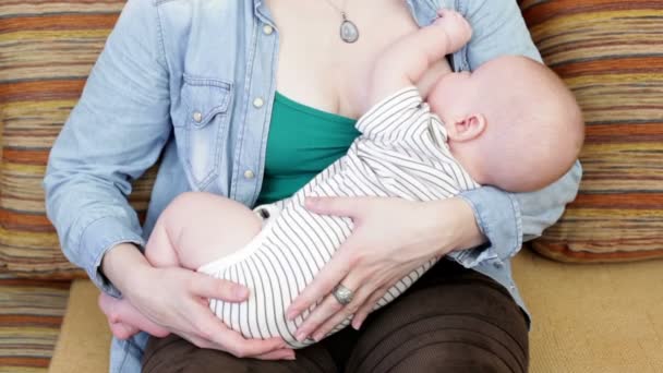 Vrouw houden en voeden van een baby — Stockvideo