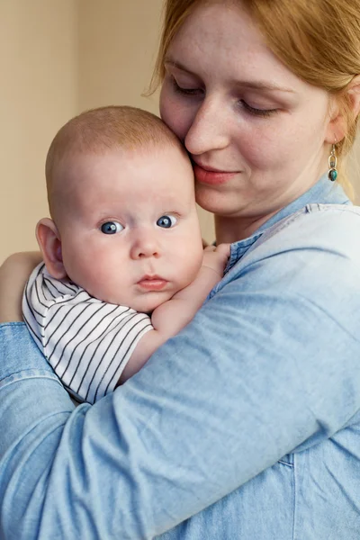 Uzavřít se mladá žena, držící dítě — Stock fotografie