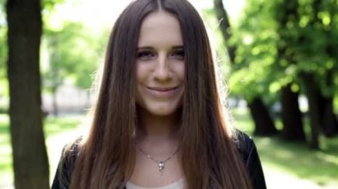 Siyah montlu genç gülümseyen kadın kapatmak