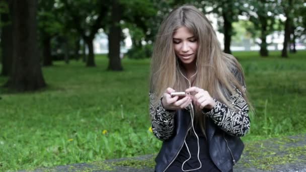 Móvil. Mujer rubia joven está escuchando música — Vídeo de stock