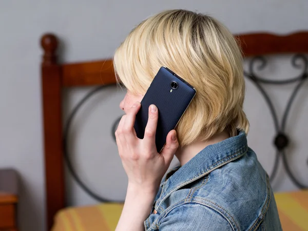 Mujer rubia sosteniendo un móvil, hablando por teléfono — Foto de Stock