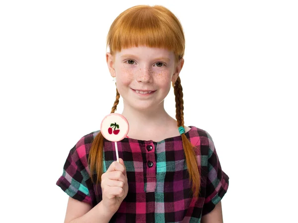 Little redheaded girl holding a candy — Stock Photo, Image