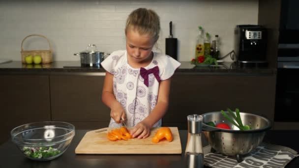 Niña preparando ensalada en la cocina — Vídeo de stock