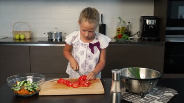 Niña preparando ensalada en la cocina — Vídeo de stock