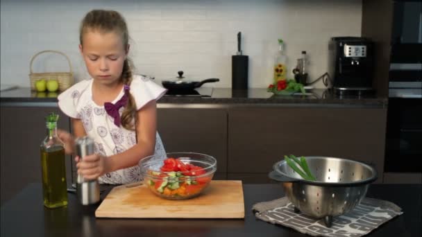 Niña preparando ensalada en la cocina — Vídeo de stock