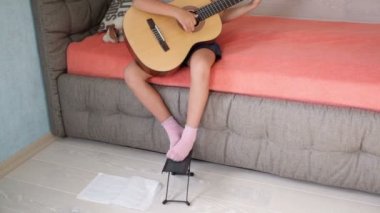 Küçük kız kanepede gitar çalmak