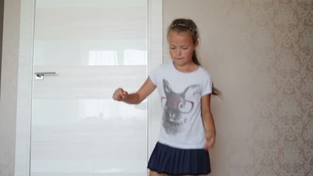 Маленька дівчинка стрибає на килимку — стокове відео