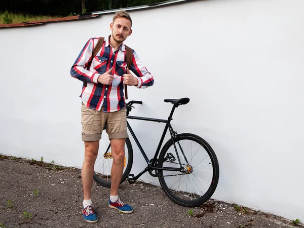 Junger Hipster-Mann steht neben seinem Fahrrad — Stockfoto