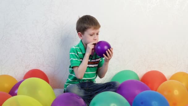 Un niño jugando en casa con globos — Vídeos de Stock