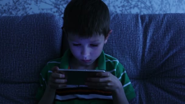 Liten pojke spelar på en smartphone — Stockvideo