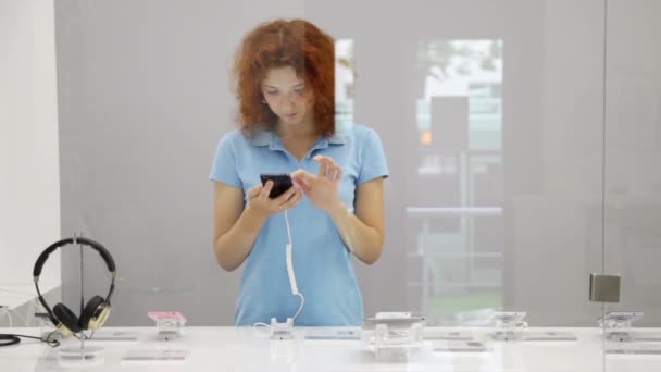 Femme choisissant smartphone en magasin — Video