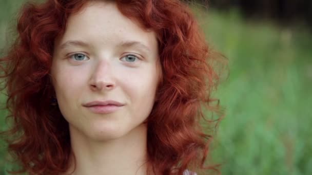 Femme en lunettes de soleil souriant contre l'herbe verte — Video