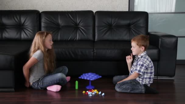 Брат и сестра играют на полу — стоковое видео