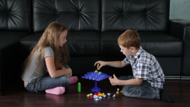 Hermano y hermana están jugando en el suelo — Vídeo de stock