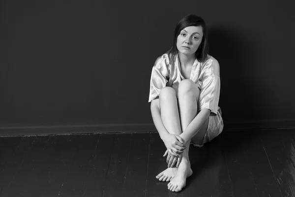 Mujer triste sentada en la esquina de una habitación — Foto de Stock